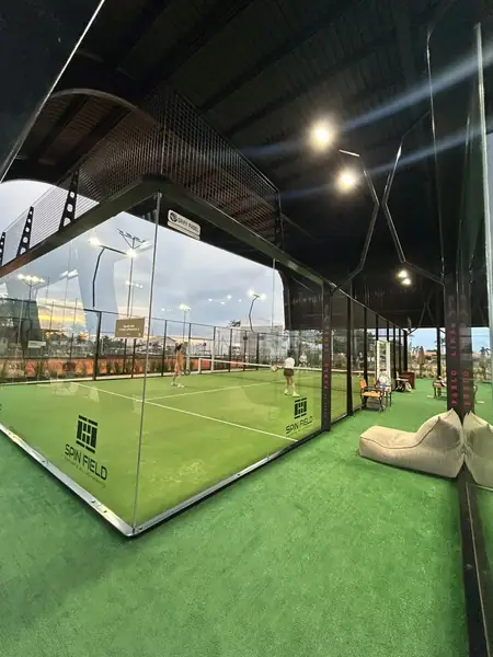 Quadra coberta de padel com estrutura e teto escuro