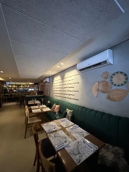 Restaurante com painéis acústicos no teto e banco verde