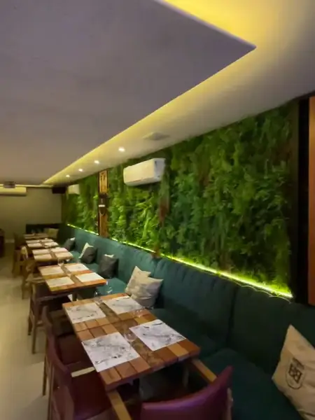 Restaurante com parede verde e painéis no teto